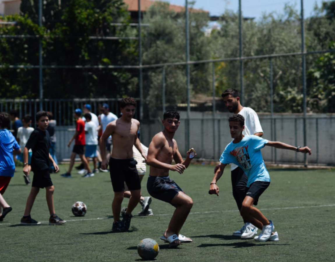 Teenagers playing football together at Yael Camp